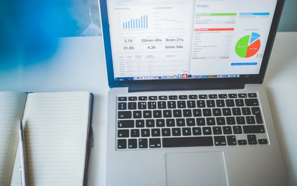 Dizüstü ekranında reklam ve performans paneli grafikleri, yanında defter